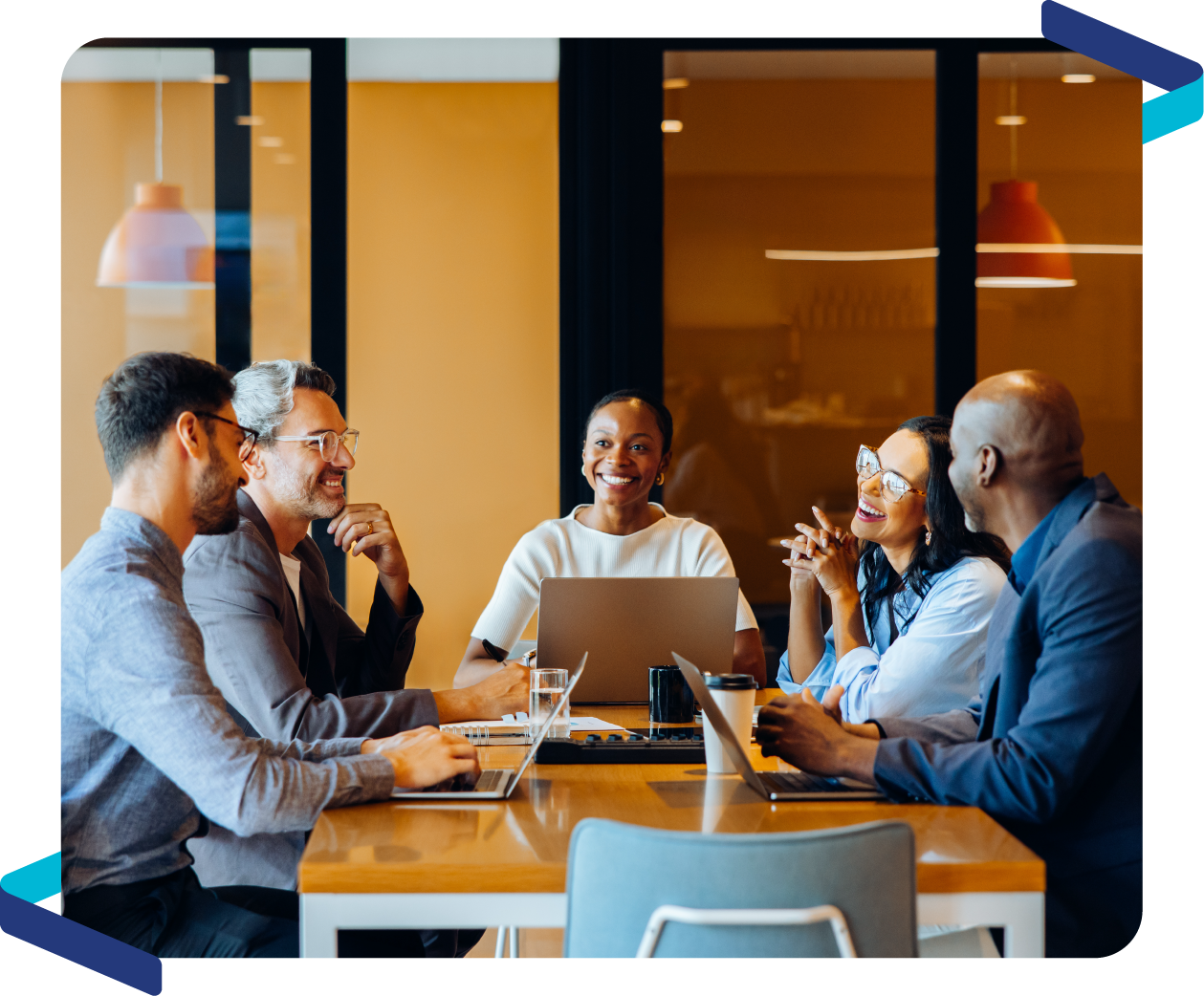 Team meeting in a conference room with laptops and collaborative discussion.